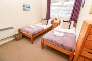 2 camas individuales en una habitación con ventana en The Chace, en Redruth
