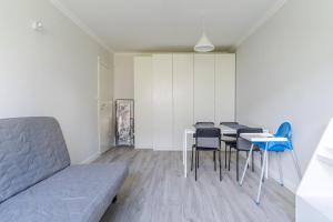 a room with a table and chairs and a couch at Black Chairs - Apartament blisko morza in Gdańsk