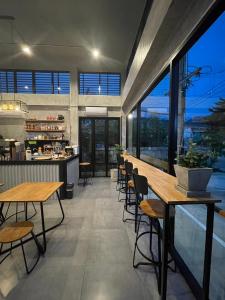 a restaurant with wooden tables and chairs and windows at Loft Space Hotel in Ranong