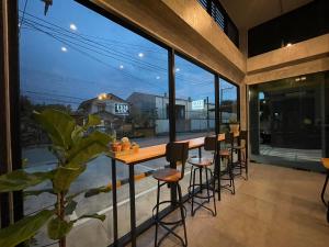 a bar on the balcony of a house with a large window at Loft Space Hotel in Ranong