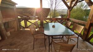 a table and chairs on a porch with the sun shining at Izvor in Ogulin