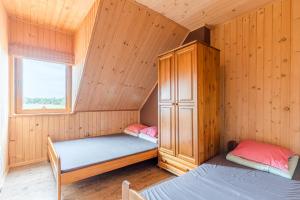 オストロボにあるDomki Letniskowe Corleoneの木造キャビン内のベッドルーム1室(ベッド2台付)