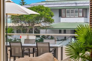 a balcony with a table and chairs and a building at Byron Bay Accom Unit 1 2 Fletcher Street Pipis on the Beach 1 in Byron Bay