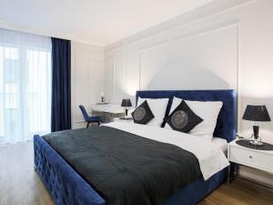 Un dormitorio con una cama azul y blanca y un escritorio en Luksusowy apartament z sauną en Zamość