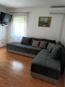 a living room with a couch and a flat screen tv at Apartmani MM in Tkon