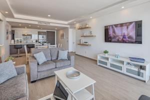 ein Wohnzimmer mit Sofa und Tisch in der Unterkunft Brand New Contemporary 1 Bed Oceanfront Condo at Encantame Towers Verano E1203 in Playa Encanto
