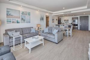ein Wohnzimmer mit 2 Sofas und einer Küche in der Unterkunft Brand New Contemporary 1 Bed Oceanfront Condo at Encantame Towers Verano E1203 in Playa Encanto