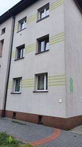 un edificio con strisce gialle e bianche sopra di Apartament Ogrodzieniec a Ogrodzieniec