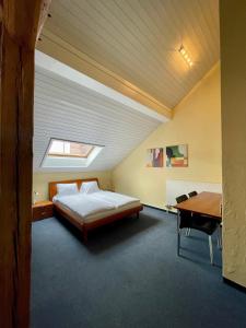 a bedroom with a bed and a desk and a window at Hotel Bären Suhr in Aarau