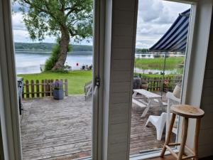 a door to a deck with a view of the water at Sjötomt i Mariefred in Mariefred