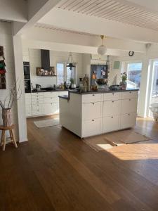 een grote keuken met witte kasten en een houten vloer bij Sjötomt i Mariefred in Mariefred