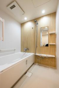 uma casa de banho com uma banheira e um espelho. em アルファベットイン那覇国際通りEAST em Tsuboya