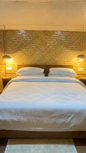una camera da letto con un grande letto bianco con due cuscini di Deoja Forest Stay a Darjeeling