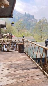 un ponte di legno con vista sulle montagne di Deoja Forest Stay a Darjeeling