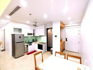 河內的住宿－Linh Homestay，厨房配有白色橱柜和桌椅