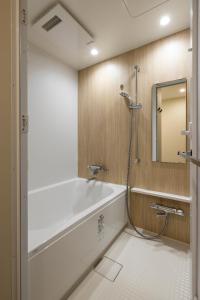 W łazience znajduje się wanna oraz prysznic z lustrem. w obiekcie アルファベットイン那覇国際通りEAST w mieście Tsuboya