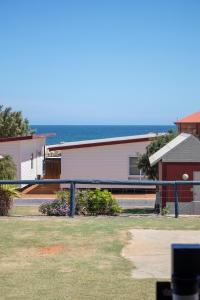 una casa con el océano en el fondo en Seaspray Beach Holiday Park, en Dongara