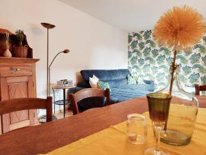 ein Wohnzimmer mit einem Tisch und einer Vase darauf in der Unterkunft Gästehaus Röhm in Ilbesheim
