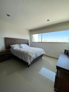 1 dormitorio con cama y ventana grande en Loft en Cholula a 10min de Angelopolis en Cholula