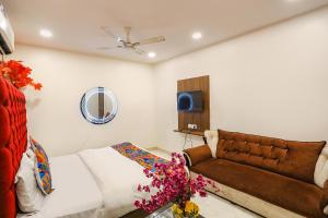 a bedroom with a bed and a couch at FabHotel Royal Galaxy I in New Delhi