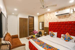 um quarto com uma cama grande e uma cabeceira vermelha em FabHotel Royal Galaxy I em Nova Deli