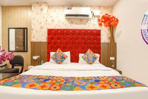 a bedroom with a large bed with a red headboard at FabHotel Royal Galaxy I in New Delhi