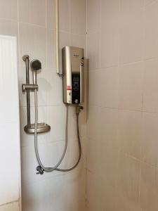 a shower in a bathroom with a phone on the wall at Aekkalukthai Hostel Rayong in Rayong