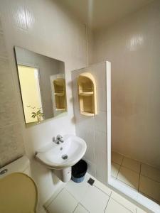 y baño con lavabo, aseo y espejo. en Aekkalukthai Hostel Rayong, en Rayong