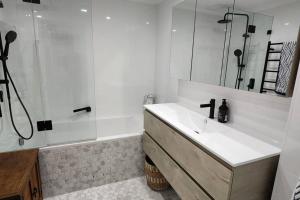 bagno bianco con lavandino e doccia di Homely Apartment In Sought After Building a Sydney