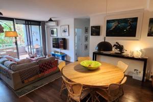 un soggiorno con tavolo e divano di Homely Apartment In Sought After Building a Sydney