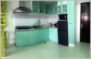 a kitchen with blue cabinets and a black refrigerator at Kalimera Baguio Home in Baguio