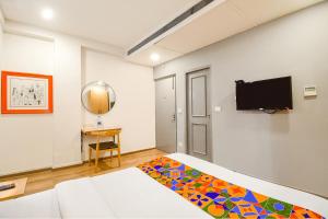 a bedroom with a bed and a flat screen tv at FabHotel Airport Green Arcade in Kolkata