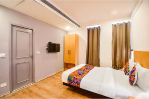 1 dormitorio con 1 cama y TV en FabHotel Airport Green Arcade en Calcuta