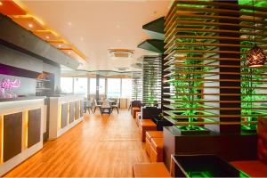 un restaurante con una gran pared de botellas de vino en FabHotel Airport Green Arcade - near Kolkata Airport, en Calcuta