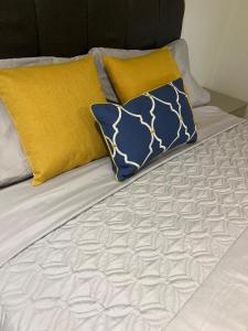 Una cama con almohadas amarillas y azules. en Modern 1 bedroom flat high street, great location, en Hemel Hempstead