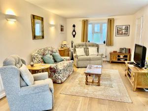 a living room with two couches and a tv at Clematis House in Dorchester