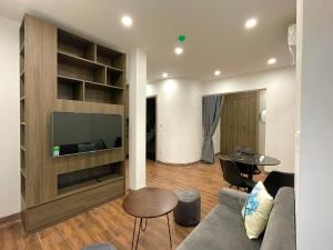 Homestay Vũ Miên, Tây Hồ, Ba Đình في هانوي: غرفة معيشة مع أريكة وتلفزيون وطاولة