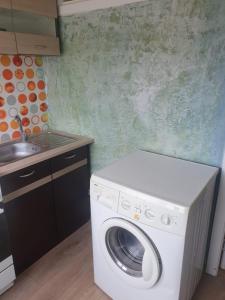 a washing machine in a kitchen next to a sink at Apartament Erfolg 7 in Daugavpils