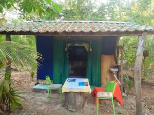 a small house with chairs and a table in front of it at Jungle Tent 3x3, Latino Glamping & Tours, Paquera in Paquera