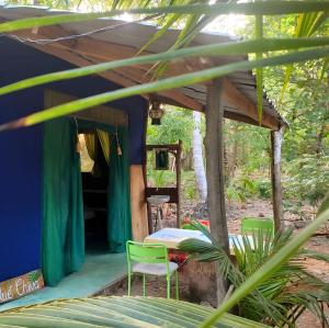 a house in the woods with a table and chairs at Jungle Tent 3x3, Latino Glamping & Tours, Paquera in Paquera