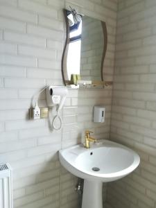 een badkamer met een witte wastafel en een spiegel bij Come & Rest in Kazbegi