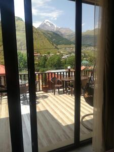 een uitzicht vanuit een raam van een terras met een tafel bij Come & Rest in Kazbegi