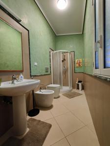 ein Bad mit einem Waschbecken, einem WC und einer Dusche in der Unterkunft Appartamenti in Villa Polimnia in Fontane Bianche