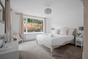 a white bedroom with a bed and a window at Bay View Luxury Stays - Southdown in Overcombe
