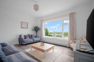 sala de estar con sofá, mesa y ventana en Bay View Luxury Stays - Southdown en Overcombe