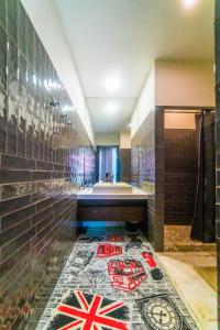 a bathroom with a bath tub and a tile floor with a mosaicarijavascript at Manica Esentai City in Almaty