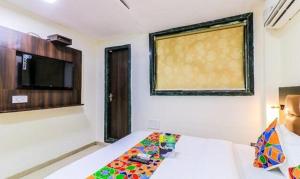 a bedroom with a bed and a tv and a window at FabHotel Galaxy Suite in Mumbai