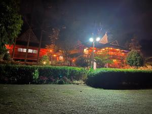 a building with a street light in front of it at night at Para para cafe & cottage in Berastagi