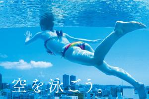 een man zwemmend in het water in een zwembad bij Hotel Aqua Citta Naha in Naha