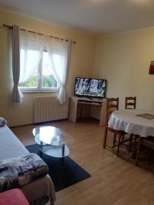 a living room with a couch and a table and a tv at Guest House Surina in Rupa